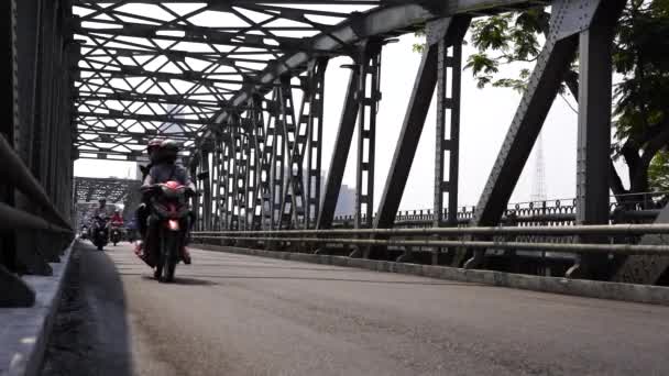 ベトナムのフエ 2020年3月12日 ベトナムのフエ町の川を渡る自動車と歩行者用鋼製の橋 橋を渡って道路上のバイクの人々 — ストック動画