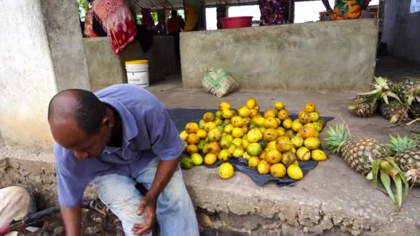タンザニアのザンジバル 10月30 2019 アフリカ人男性は 東アフリカタンザニアのザンジバル島の地元のストリートフード市場でトロピカルフルーツを販売しています — ストック動画