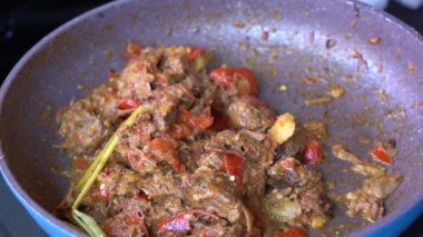 Soğanlı kızartma tavası, limon otu, kırmızı biber ve sığır eti, yakından. Endonezya 'da. Sambal Goreng Ati Kentang, Endonezya mutfağı, baharatlı biftek buluşması ve limon otu yaprağı ve kırmızı biberli patates garnitürü.