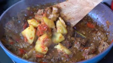 Soğanlı kızartma tavası, limon otu, kırmızı biber ve sığır eti, yakından. Endonezya 'da. Sambal Goreng Ati Kentang, Endonezya mutfağı, baharatlı biftek buluşması ve limon otu yaprağı ve kırmızı biberli patates garnitürü.