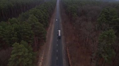 Dev tank kamyonunun ya da yakıt kamyonunun havadan görüntüsü. Ormanın asfalt yolunda, otoban manzaralı.