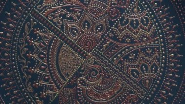 Dekoratif seramik tabak, siyah ve altın renkli, arka planda boyalı plaka, yakın plan, üst manzara, döndürme. Akrilik boyalarla boyanmış dekoratif porselen tabaka, el işi, nokta boyası.