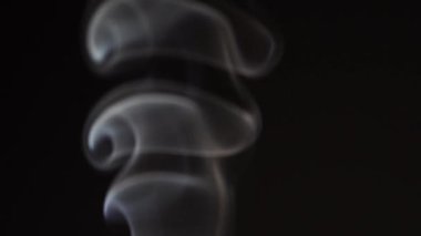 Siyah arka planda beyaz duman yavaş çekimde. Beyaz buhar döner ve yükselir.