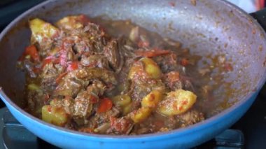 Soğanlı kızartma tavası, limon otu, kırmızı biber ve sığır eti, yakından. Endonezya 'da. Sambal Goreng Ati Kentang, Endonezya mutfağı, baharatlı biftek buluşması ve limon otu yaprağı ve kırmızı biberli patates garnitürü.