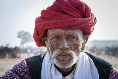 Pushkar, Hindistan - 17 Kasım 2018: Pushkar Camel Mela sırasında çölde Hintli adam Pushkar, Rajasthan, Hindistan yakınlarında. Bu fuar dünyanın en büyük deve ticaret fuarı.