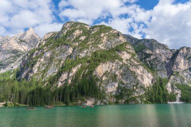 Lago di Braies, İtalya - 26 Ağustos 2021: İnsanlar Alp Gölü Braies, İtalya 'da tahtadan yapılmış geleneksel tekneleri kürek çekiyorlar. Dolomitlerdeki resimli dağ gölü
