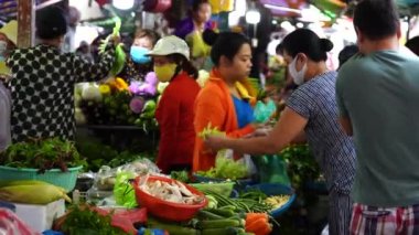 Ho Chi Minh, Vietnam - 23 Mart 2020: Vietnamlılar Ho Chi Minh, Vietnam şehir merkezindeki bir sokak gıda pazarında meyve ve sebze satıp alıyor.
