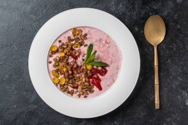 Kırmızı çilekli beyaz tabak, granola ve siyah arka planda doğal yoğurt, yakın plan, üst manzara