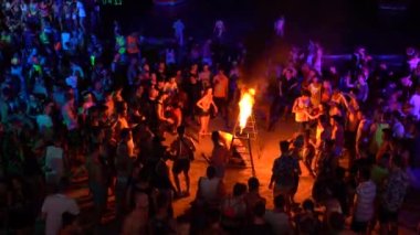 KOH PHANGAN, THAILAND - 20 HAZİRAN 2019: Erkekler ve kızlar kumsalda gece yarısı ateşle kavşak altında sürünüyorlar, Koh Phangan, Tayland 'daki Koh Phangan adasında yangın gösterisi