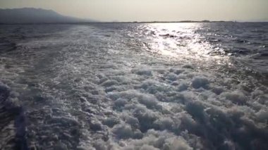 Hızlı yat teknesiyle mavi okyanus suyu dalgası pervane yıkama köpüğünü uyandırıyor. Geminin hareketi sırasında su damlaları sıçrıyor. Seyahat ve doğa kavramı. Yavaş çekim