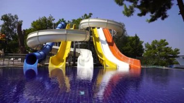 Aquapark amusement rides and swimming pool next to the sea in Turkey. Multi colored water slides and pool, outdoor. The concept of vacation and entertainment