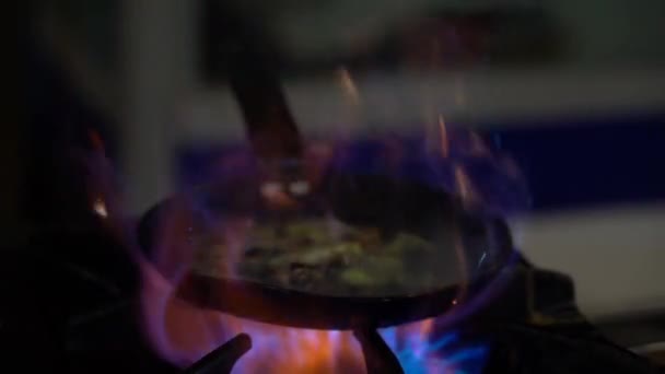 シェフのフライパンでソーセージや野菜をフライパンに投げつける トルコのストリートカフェで大きな火の炎の上に野菜とフライパンのスローモーションビュー キッチンで野菜炒め料理 — ストック動画