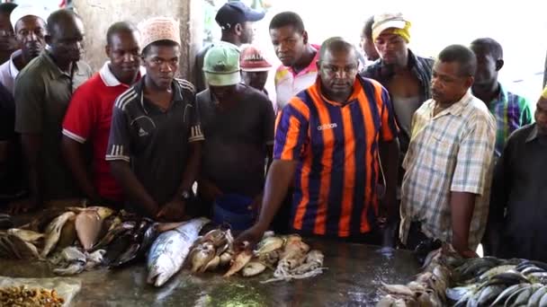 タンザニアのザンジバル 2019年11月4日 アフリカの男性は 東アフリカタンザニアのザンジバル島で地元のオークションで新鮮な海魚を販売しています — ストック動画