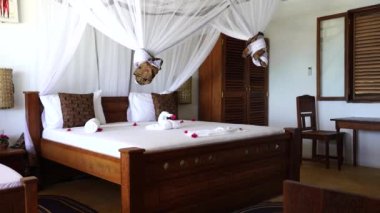 Lüks gösteriler için dekore edilmiş dört poster yataklı bir yazlık yatak odası. Denizdeki tropik villanın iç tasarımı, Zanzibar adası, Tanzanya, Afrika, çekim alanı