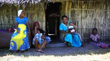 Zanzibar, Tanzanya - 13 Aralık 2019: Afrika ailesi Zanzibar, Tanzanya, Doğu Afrika 'da saman bir evin yanında oturuyor