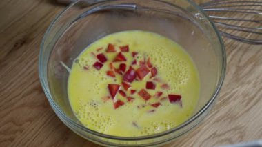 Şef omlet yapmak için kırmızı biber ve yeşil dereotlu yumurta çırpıyor. Mutfak pişirme konsepti