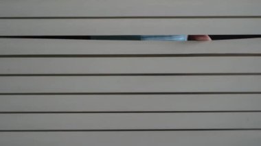 İçerideki koruyucu maskeli genç kızın ön portresini kapat. Pencere perdelerini elleriyle it. Geceleri korkusuzca dışarı bakıyorum.