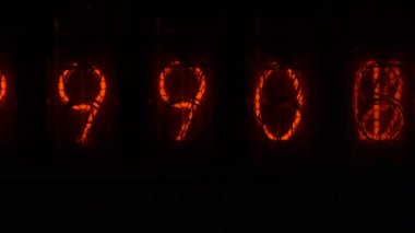 Cihazın üzerindeki vakum tüpü görüntüsü saniyeleri sayıyor. Vintage lamba zamanlayıcısında numaralar gösteriliyor, yakın çekim, nixie tüpü göstergesi. Parlama deşarj göstergesi