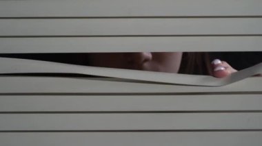 Pencereye elleriyle panjur iten genç bir kızın ön portresini kapat. Geceleri korkusuzca dışarı bakıyorum.