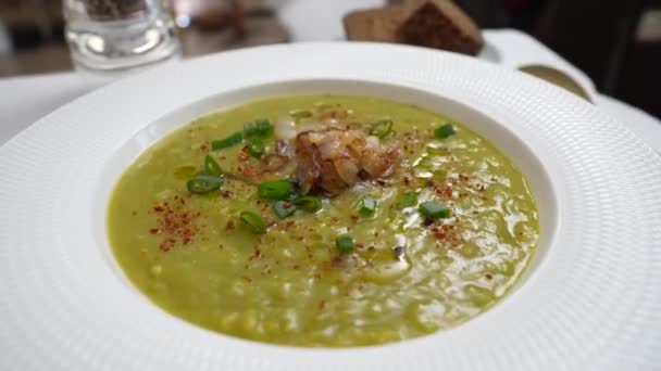 绿色豌豆奶油汤放在白盘上 桌上放香料 健康的食物 美味的干豌豆汤 — 图库视频影像
