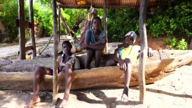 Zanzibar, Tanzanya - 16 Kasım 2019: Bilinmeyen üç Afrikalı genç, Tanzanya, Doğu Afrika 'daki Zanzibar adasında tahta bir teknede oturuyor.