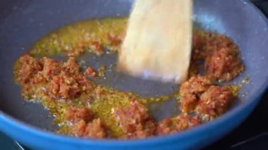 Tavada sebze yağında kızartılmış soğan, sarımsak ve kırmızı biber. Kızartma tavası, doğranmış soğan, sarımsak ve kırmızı biber, yakın çekim. Endonezya 'da. Yemek pişirmek.