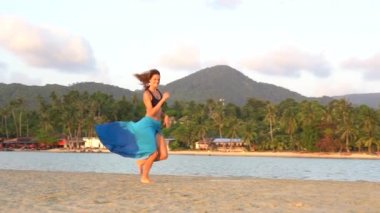 Genç güzel kız deniz kenarındaki tropikal kumsalda dinleniyor ve dans ediyor. Yaz kavramı. Tatil seyahati. Koh Phangan Adası, Tayland