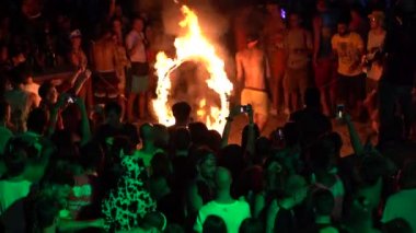 Koh Phangan, Tayland - 22 Aralık 2018 : Erkekler ve kızlar kum plajında gece ateş çemberinin üzerinden atlarlar, Koh Phangan adasındaki Full Moon partisinde ateş gösterisi, Tayland