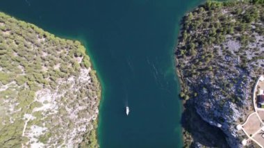 Hırvatistan, Orta Avrupa 'da yaz güneşli bir günde Krka nehri, otostrada ve kemer köprüsünün üzerinde uçmak, seyahat ve doğa kavramı. Güzel manzara ve büyük köprüsü olan mavi deniz. Havadan panorama görünümü