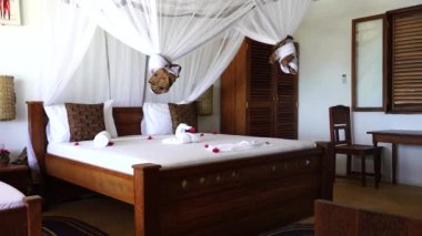 Lüks gösteriler için dekore edilmiş dört poster yataklı bir yazlık yatak odası. Denizdeki tropik villanın iç tasarımı, Zanzibar adası, Tanzanya, Afrika, çekim alanı