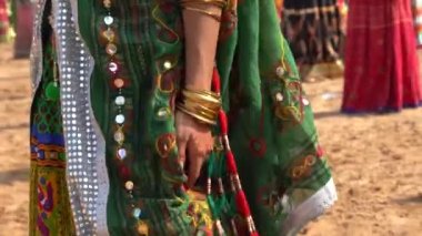 Hindistan 'ın kutsal şehri Pushkar, Rajasthan yakınlarındaki Pushkar Camel Mela' da çölde dans ettiği için Hintli bir kızın renkli kıyafetleri. Kapat.