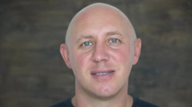 Kameraya bakan orta yaşlı, beyaz, kel bir adamın yakın çekimi. İnsanlar ve yaşam tarzı konsepti. İçerde orta yaşlı bir adamın portresi