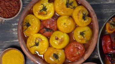 Fırınlanmış kırmızı ve sarı domates ve dolmalık biber. Ahşap bir masada fırın kabında domates ve dolma biber. Sağlıklı ve lezzetli bir vejetaryen yemeği. Kapat, üst görünüm, döndür