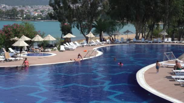 ディディム トルコ 2019年9月6日 人々はトルコのディムにあるリゾートホテルの海の隣にあるスイミングプールで泳ぎ 日光浴をします 休暇と娯楽の概念 — ストック動画