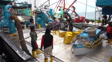 Kota Kinabalu, Malezya - 18 Şubat 2020: Malezyalı balıkçılar taze avlanan balıkları bir gemiden Kota Kinabalu, Sabah, Malezya 'daki sokak filipin pazarındaki plastik konteynırlara yüklüyorlar