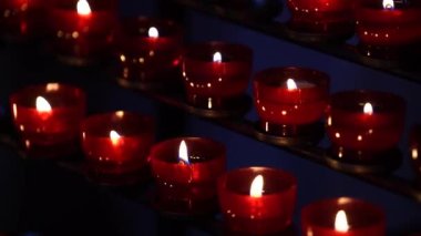 Katolik kilisesinde yanan kırmızı mumlar. İnançlı Avusturya tarafından yakılıyor. Yaklaş.