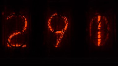 Cihazın üzerindeki vakum tüpü görüntüsü saniyeleri sayıyor. Vintage lamba zamanlayıcısında numaralar gösteriliyor, yakın çekim, nixie tüpü göstergesi. Parlama deşarj göstergesi