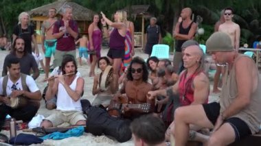 KOH PHANGAN, THAILAND - 12 Şubat 2019: Tayland 'ın Koh Phangan adasındaki deniz kıyısında gün batımında turistler için davul çalan sokak müzisyenleri