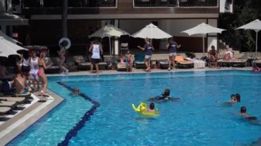 Bodrum, Türkiye - Eylül 08, 2019: Animatörler turistleri oteldeki yüzme havuzu yakınlarında ağırlıyor. Tatillerde dinlenme kavramı
