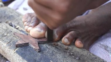 Afrikalı adam, Doğu Afrika 'daki Zanzibar adasında turistler için ahşap hediyeler hazırlıyor. Ahşap oyma Tanzanya 'da geleneksel bir el işidir.