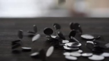 Ukrayna sikkeleri pencerenin yanındaki ahşap masaya düşüyor. Yaklaş. Ağır çekimde, gümüş para yığını ahşap zemine düşer. Ukrayna