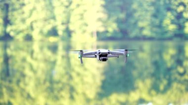 Kiev, Ukrayna - 01 Ekim 2021: DJI Maviç Air 2S İHA 'sı, bir önceki Maviç modeline göre büyük bir güncelleme yaparak, arka planda asılı duruyor. DJI Mavic Air 2S İHA 'sı orman gölünde uçuyor.