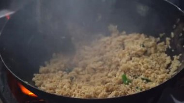 Malezyalı erkek satıcı, Malezya 'daki Kota Kinabalu, Borneo Adası' ndaki sokak yemekleri pazarında büyük bir kızartma tavasında pilav pişiriyor.