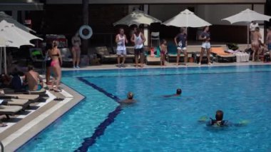 Bodrum, Türkiye - Eylül 08, 2019: Animatörler turistleri oteldeki yüzme havuzu yakınlarında ağırlıyor. Tatillerde dinlenme kavramı
