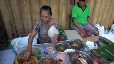 UBUD, BALI, INDONEZYA - 27 Nisan 2019: Endonezyalı fakir insanlar, Endonezya 'nın Bali adasındaki Ubud köyündeki sabah pazarında sağlıklı yiyecek satıyor ve satın alıyorlar. Sabah meyve ve sebze pazarı