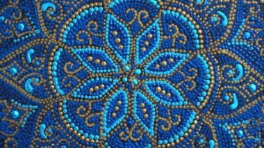 Decorative ceramic plate with blue and golden colors, painted plates, close up, rotates, handmade. Decorative porcelain plate painted with acrylic paints, handwork