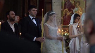MTSKHETA, GEORGIA - OCTOBER 27, 2018 : Bride and groom with lighted candles get married in the Christian Orthodox Church in historic town Mtskheta near Tbilisi, Georgia