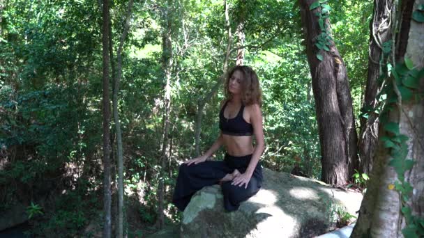 若いですCaucasianブルネットの女の子は自然の中で瞑想していますでトロピカルガーデンで夏 クローズアップ — ストック動画