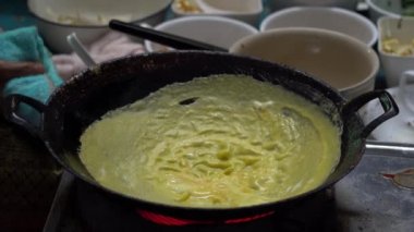 Cook Tayland 'da Bangkok' ta bir gece marketinde Tayland omleti hazırlıyor. Tayland sokak yemeği. Tayland geleneksel mutfağı. Tofu peynirli omlet, yumurta, soya fasulyesi filizi ve sebze, yakın plan.