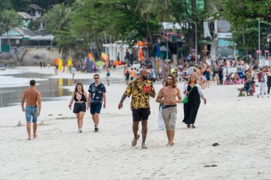 Koh Phangan, Tayland - 17 Şubat 2022: Gençler, Tayland 'daki Koh Phangan adasındaki Haad Rin plajı partisinden önce deniz kenarındaki kumlu plajda dinleniyor.